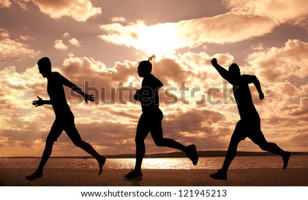 Three  people one Female and two boys runner full length silhouette against the blue sky and sun