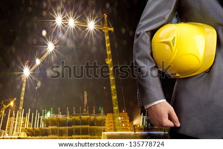 engineer yellow helmet for workers security over construction crane  Night scene