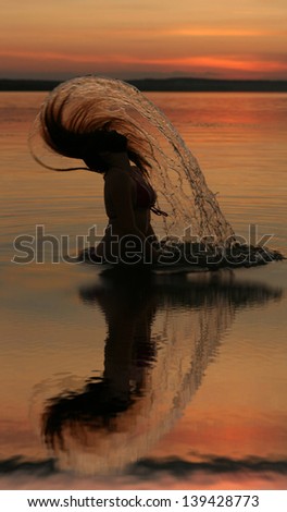 sunset yoga woman on sea coast with reflection  Silhouettes of young girl jumping in ocean at sunset