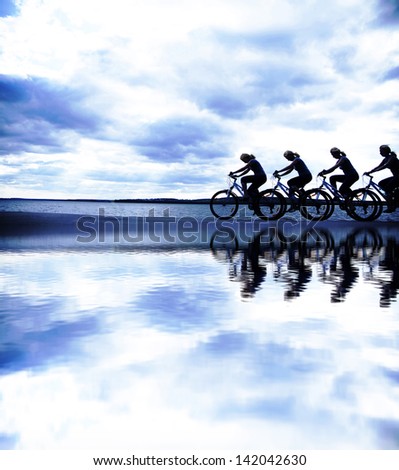 Image of sporty company friends on bicycles outdoors against sunset. Silhouette   The four phases of motion of a single cyclist along the shoreline coast