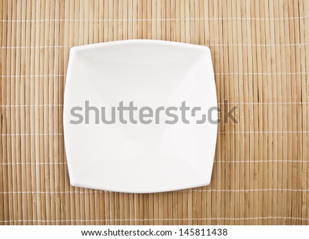 white empty bowl on a bamboo table top Copy space for inscription