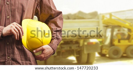 yellow helmet for workers security construction worker showing thumb up smiling in beside truck