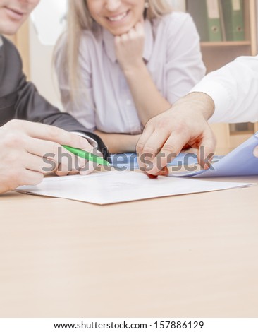 Three colleagues are discussing a table yours business plans