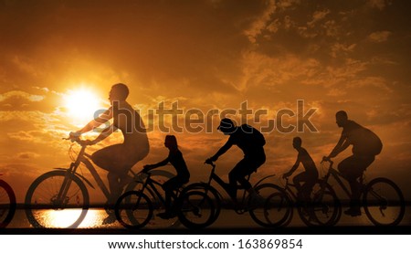 Image of sporty company friends on bicycles outdoors against yellow sunset background Silhouette A lot phases of motion cyclist along shoreline coast  Space for inscription