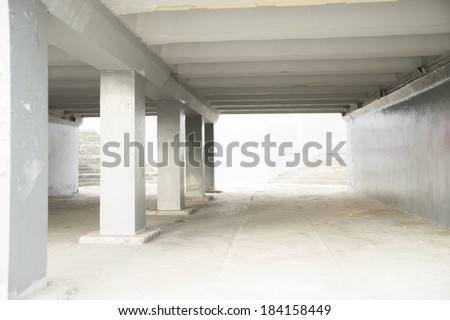 Background of Underground passage interior with lights and gray concrete columns and stairway