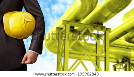 oil or gas refinery, turning on and off pipeline valve on blue sky  background torso and hand engineer yellow holding helmet for workers security construction worker No face Unrecognizable person