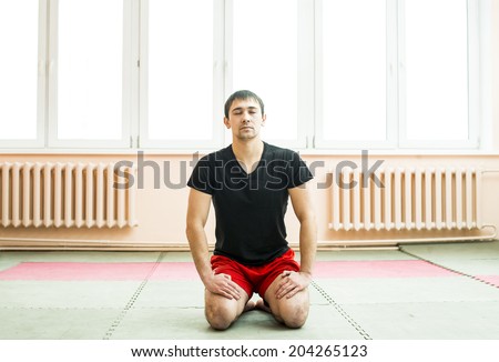 Front view of asian man meditating and finding a zen moment Male sitting judo on tatami Copy space for inscription