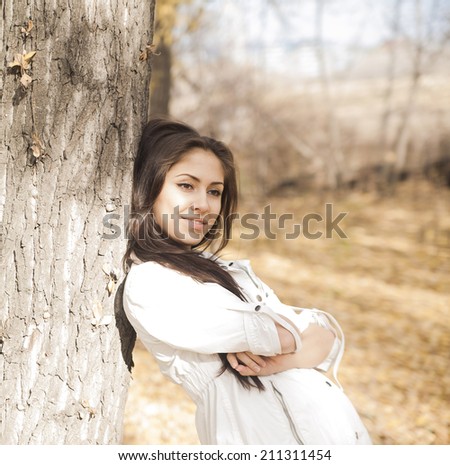 Outdoors portrait of gorgeous fall fashion latin hispanic girl. Empty Copy Space for inscription Texture trunk Empty space for inscription Cute woman with long brunette hair