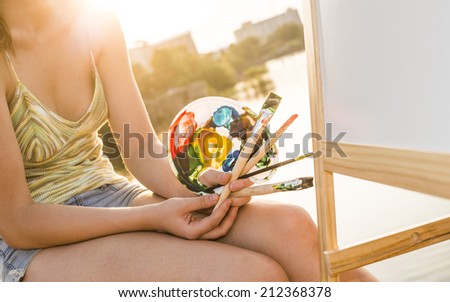 No face Torso and hands artist paints a picture of oil paint brush in hand with palette closeup Empty copy space for inscription Woman holding instruments Focus on fingers Unrecognizable person
