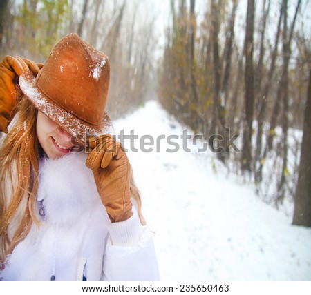 No face Unrecognizable person Beautiful cute young adult woman or girl in winter park Empty copy Space for inscription Female wearing brown leather gloves and closes his eyes hat with snowflakes
