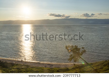 Nature background of sunset sky with clouds Sun set rays light above stone mountain Line on water in sea texture Family play on coast beach with sand  One alone tree on green field meadow