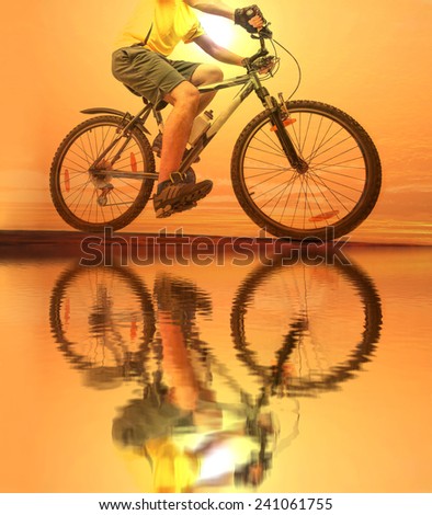Unrecognizable person No face Mountain Biker on sky with clouds background Man wear yellow sport shirt gray snickers and shorts Empty copy space for inscription Reflection sun on yellow water texture