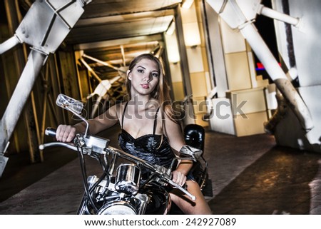 Portrait of young adult caucasian hot amazing  Biker girl in black leather shorts on a motorcycle Cute sexy woman with long brown hair looking at camera Empty copy space for inscription