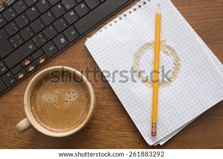 White notebook paper texture with stain from coffee cup Yellow pencil lie on round spot Business objects lie on wooden natural material table Black modern keyboard near hot mug with brown foam