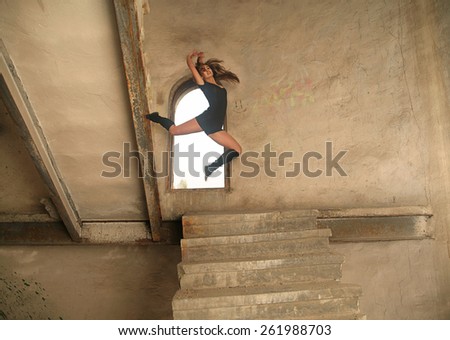 Backdrop of Full length body Portrait of Dancer jump in fly woman in black pantyhose dress girl sitting in window textured yellow dirty wall with rusty metal concrete stairway up and down background