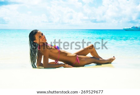 young adult girl person Exotic Hideaway Tanning Pleasure  Face of cute woman with beautiful tanned brown sexy skin body on tropical white sand beach on blue sky background with clouds Yacht on horizon