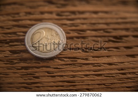 one 2 Euro coin lie on wooden surface background Empty space for inscription