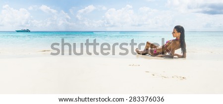 young adult girl person Exotic Hideaway Tanning Pleasure Face of cute woman with beautiful tanned brown sexy skin body on tropical white sand beach on blue sky background with clouds Yacht on horizon