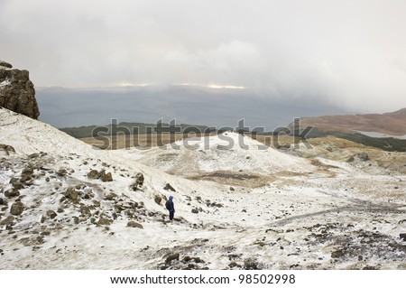 Woman on mountain path covered in snow,