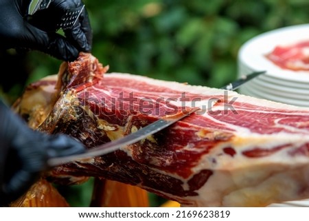 Master slicer taking iberian cured ham with tongs Foto stock © 