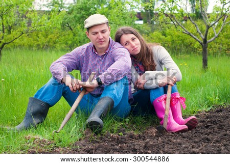 Family in the Garden resting after work. Woman and Man  Working in the Garden together. Healthy Lifestyle