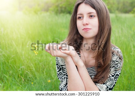 Beautiful Woman with Flowers  in Summer Park. Portrait of Pretty Girl in Sun Rays.