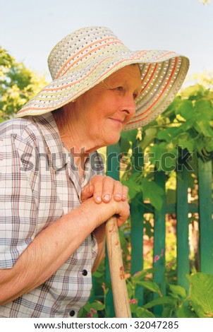 old woman in hat working in the garden