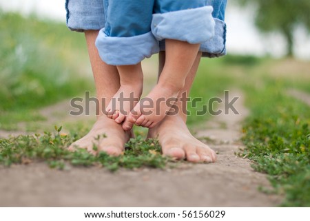 Happy Family on a Walk in Summer. Child with Father Together. Feet Barefoot on Green Grass. Healthy Lifestyle. Dad and Son. Spring Time