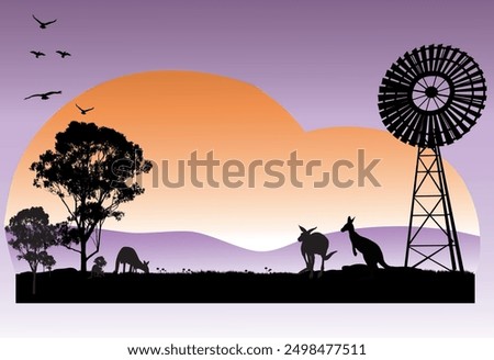 Outback Australia silhouette scene of kangaroos feeding in the sunset and windmill