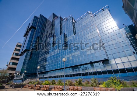 Shiny glass office building against blue sky - Photograph of a smart looking glass office building taken on a very bright sunny day in early spring.