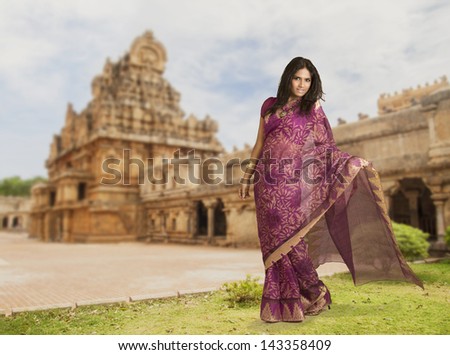 Beautiful Indian girl in traditional Indian sari on temple background.