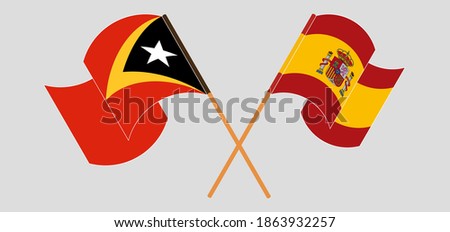 Crossed and waving flags of East Timor and Spain