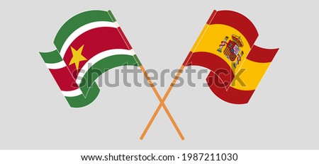 Crossed and waving flags of Suriname and Spain