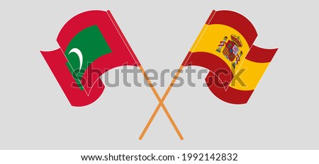 Crossed and waving flags of Maldives and Spain