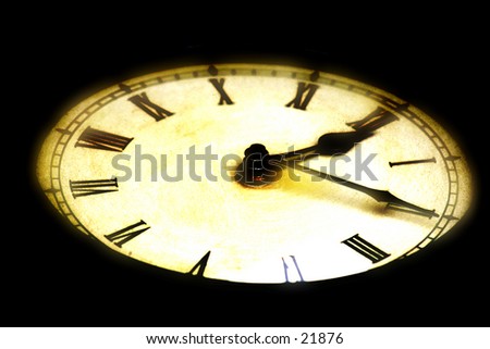 Glowing, selective focus antique clock. Black background.