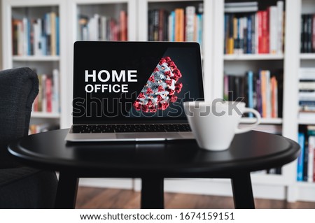 Home office theme. Home office during coronavirus pandemic. Novel coronavirus 2019 COVID-19 theme. Coronavirus wallpaper on computer. Coffee Cup in foreground.