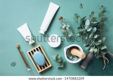 White cosmetic bottles, eucalyptus flowers, towels, soap on green background. Top view, flat lay. Natural organic beauty product concept. Spa, skin care, body treatment. ストックフォト © 