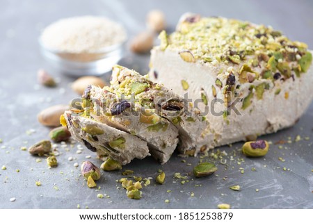 Sesame halva with pistachios on grey background. Top view. Copy space. Traditional middle eastern sweets. Jewish, turkish, arabic national dessert. Turkish delight.