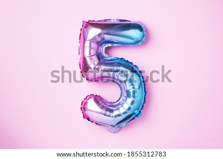 Creative layout. Rainbow foil balloon number and digit five 5. Birthday greeting card. Anniversary concept. Top view. Copy space. Stylish colored numeral over pink background. Numerical digit 商業照片 © 