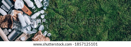 Reuse garbage, recycle, plastic free. Food plastic packaging, trash on green moss background after picnic in forest. Top view. Copy space. Recycling plastic. Environmental pollution, ecology concept