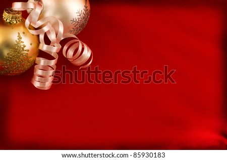 Christmas greeting card. Red textile background with decorative gold and silver baubles and serpentine.