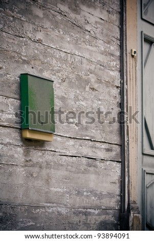 Old green mailbox to a wooden wall