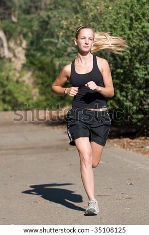 Young woman in black jogs outside