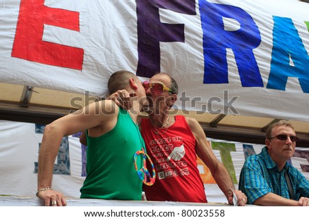 PARIS, FRANCE - JUNE 25. Two men kiss in the Paris Gay Pride parade to support the LGBT\'s(lesbian, gay, bisexual, and transgender) rights, on June 25, 2011 in Paris, France.