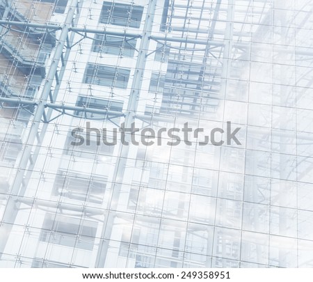 Architectural background of a modern high-rise building with a clear glass facade and view through to the staircases between floors forming a parallel pattern