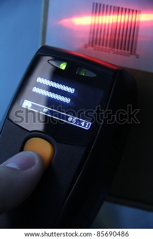 hand is holding a handheld barcode scanner