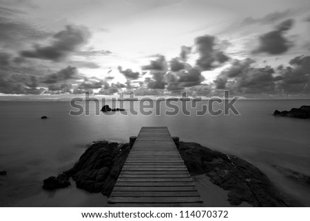 Wooden pier at the beach in the morning light,black and white.
