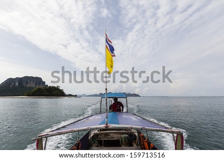 KRABI, THAILAND - JULY 7 : Unidentified boat driver and longtail boat ride on the shuttle service tourists to the islands on July 7,2013 in Krabi ,Thailand.