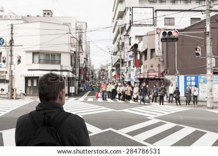 OSAKA JAPAN - APRIL 22 : Unidentified people waited to cross the road in Osaka,Japan on April 22,2015. Osaka is the third largest city and an economic and entertainment hub of Kansai region.