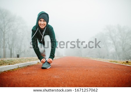 Similar – Image, Stock Photo Sporty woman tying laces on sneakers before training